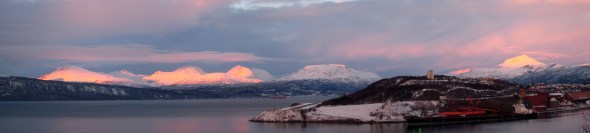Low sun shines on the mountain peaks by the Ofoten Fjord