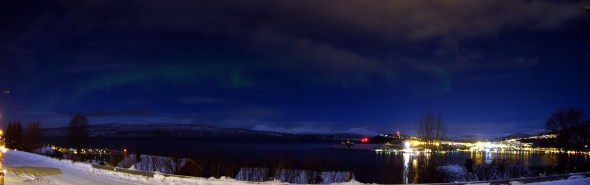 Northern light (aurora borrealis) with moon shining on the mountains in the background