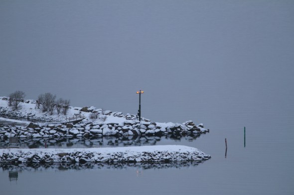 Breakwater at the Ankenes Marina with the runway light beacon for the minicipal airport
