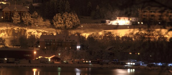 A long exposure from the waterfront in the city. The yellow blobs that stretches out horizontally, is just the snowplow's yellow, blinking warning light as it thunders into the Fagernes Tunnel